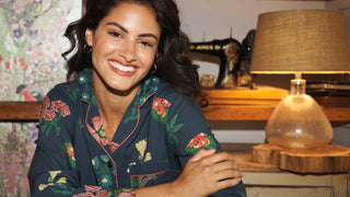 smiling Model wears floral pyjamas sat at a table