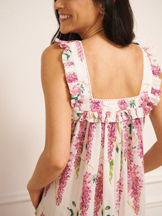 Model wears a nightie in wisteria print and with frills on the sleeves. the nightie has pockets. back detail
