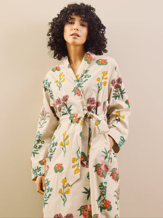 Woman wearing a floral dressing gown  against a beige background