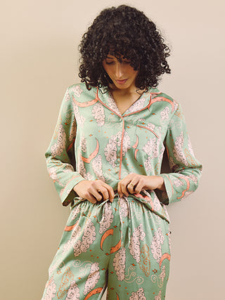 Model wearing a green moon and clouds design long satin pyjama set against a beige background