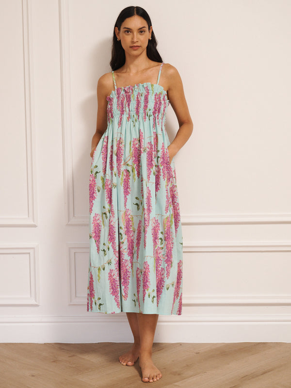 Model wearing a duck egg blue cotton cami midi night dress with pink wisteria print, featuring a shirred bodice and thin straps.