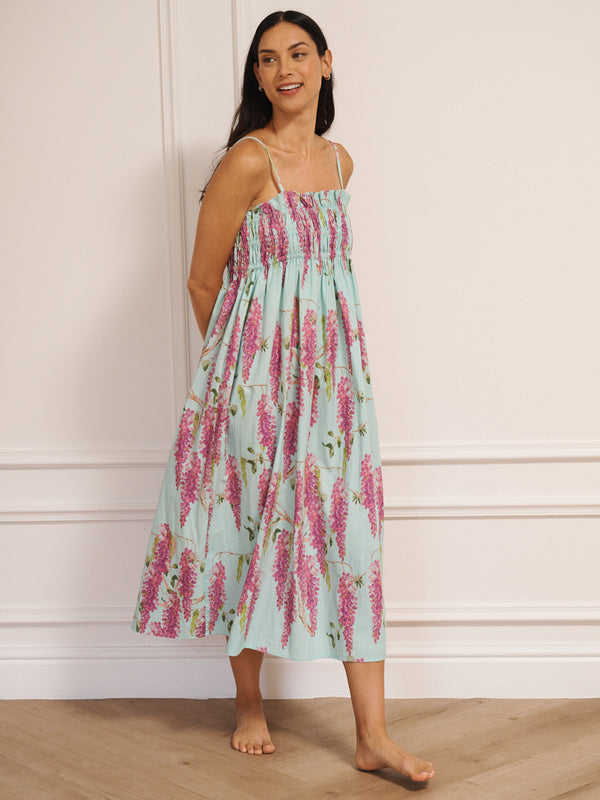 Model wearing a duck egg blue cotton cami midi night dress with pink wisteria print, featuring a shirred bodice and thin straps.