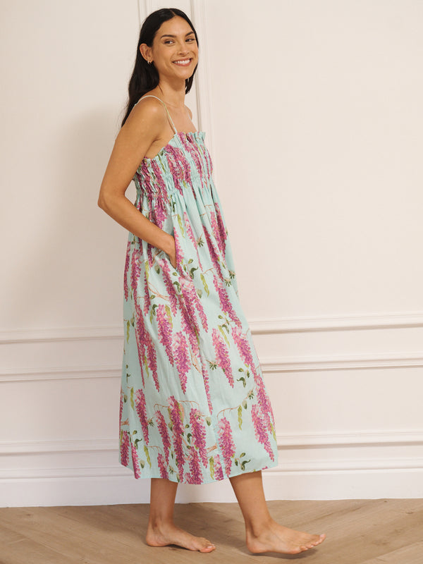 Model wearing a duck egg blue cotton cami midi night dress with pink wisteria print, featuring a shirred bodice and thin straps.