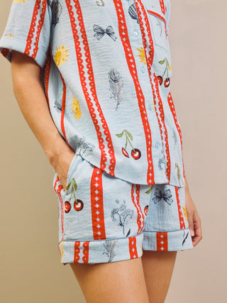 Person wearing a patterned short pyjama set red and blue stripes on a beige background