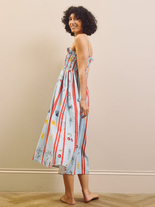 Woman wearing a colorful nightdress with a pattern against a beige wall.