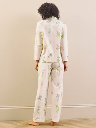 Person wearing a floral pyjama set standing against a plain wall.