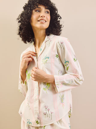 Woman wearing a floral pyjama set against a beige background