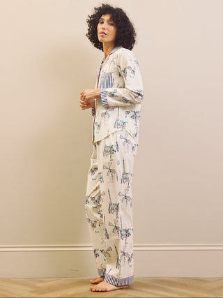 Woman wearing a navy and white Paris print pyjama set against a plain background