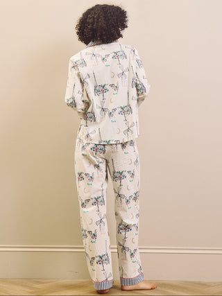 Woman wearing a navy and white Paris print pyjama set against a plain background