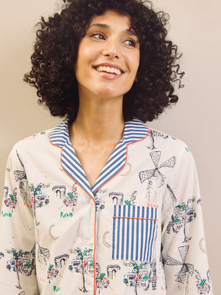 Woman wearing a navy and white Paris print with stripes pyjama set against a plain background