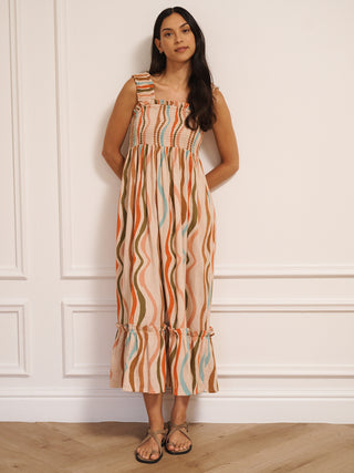 Model wearing Their Nibs linen mix ruched body midi dress in oatmeal rainbow waves print, front view