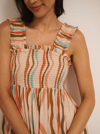 Model wearing Their Nibs linen mix ruched body midi dress in oatmeal rainbow waves print, detail view