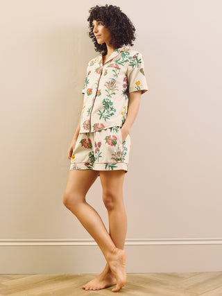 Woman wearing a floral pyjama set against a plain background