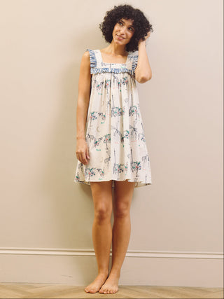 Woman wearing a Paris themed printed nightdress against a plain background 