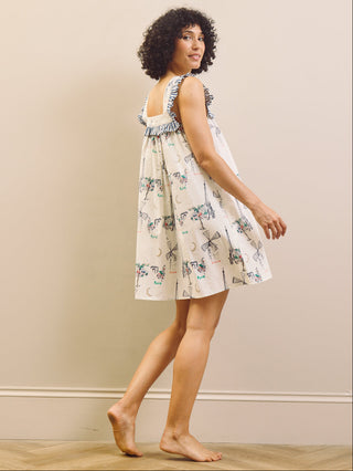 Woman wearing a Paris themed printed nightdress against a plain background 