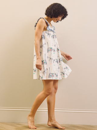 Woman wearing a Paris themed printed nightdress against a plain background 