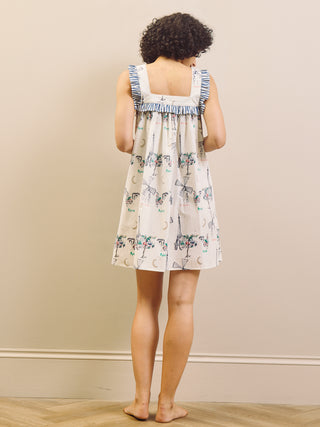 Woman wearing a Paris themed printed nightdress against a plain background 