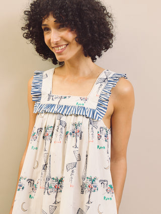 Woman wearing a Paris themed printed nightdress against a plain background 