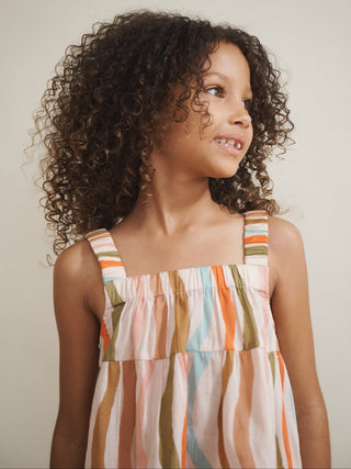 Young girl wearing a striped pyjamas against a plain background