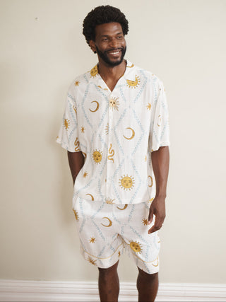 Man wearing a cream pyjamas with celestial pattern against a plain background