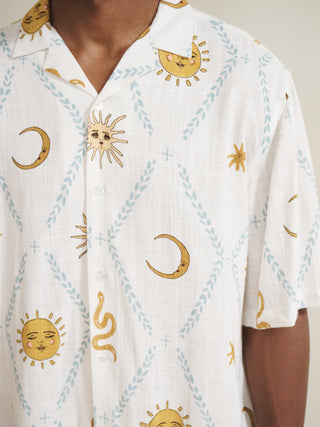 White pyjama top with gold celestial pattern worn by a model