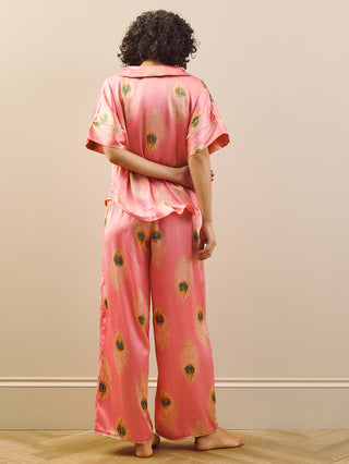 model wears pink long oversized pyjama set with peacock feather design. Back