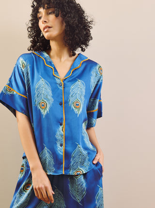 model wears blue long oversized pyjama set with peacock feather design detail