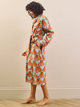 model wears a grandpa robe against a plain wall, side