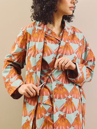 model wears a grandpa robe against a plain wall, tie