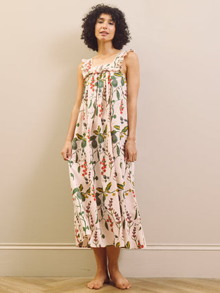 Woman wearing a floral & Pear night dress against a plain background