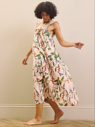 Woman wearing a floral & Pear night dress against a plain background