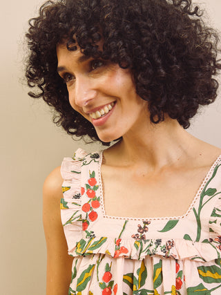 Woman wearing a floral & Pear night dress against a plain background