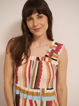 Model wearing a multicolour striped cotton tiered dress with shirred bodice and wide ruffled straps,  strap detail