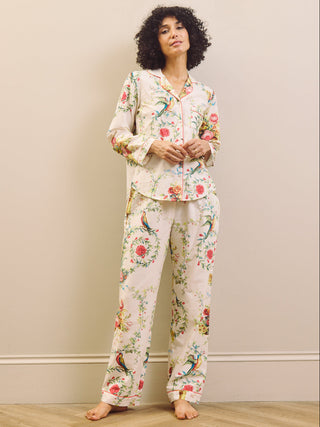 Woman wearing a floral pyjama set against a plain background