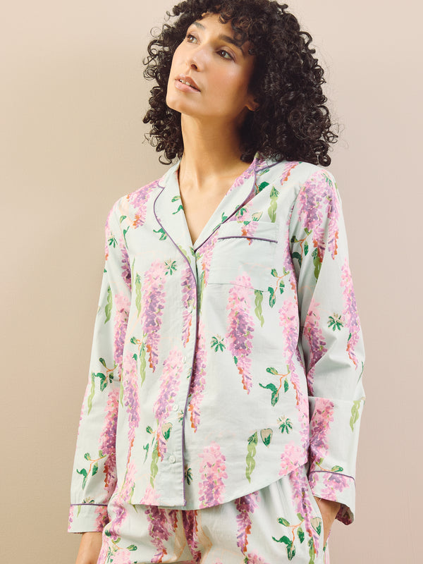 model wears long wisteria print pyjamas on beige background