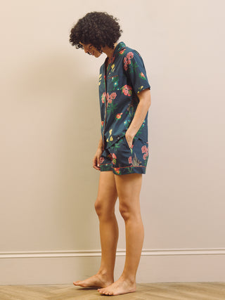 Woman wearing a navy floral short pyjama set against a plain background