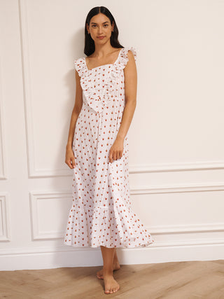Model wearing white cotton seersucker nightdress with tiny sacred heart print, V-shaped frill neckline and midi-length hem, photographed against a neutral studio wall.