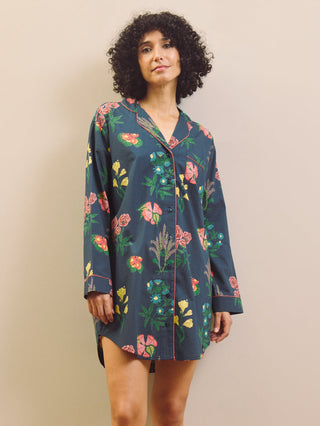 Woman wearing a navy floral patterned nightshirt against a plain background