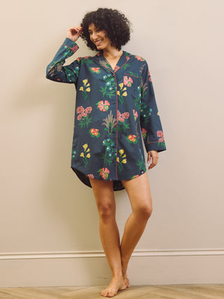 Woman wearing a navy floral patterned nightshirt against a plain background