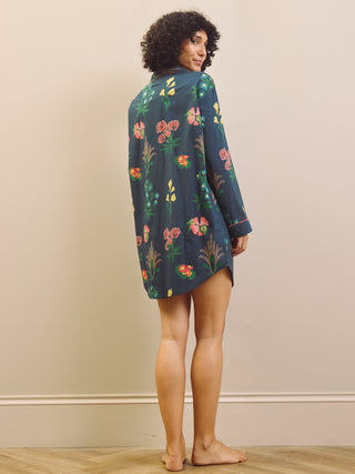 Woman wearing a navy floral patterned nightshirt against a plain background