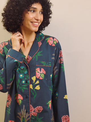 Woman wearing a navy floral patterned nightshirt against a plain background