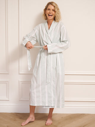 Model wearing women’s aqua brushed stripe cotton robe with tie waist and midi length, photographed barefoot in a neutral studio setting. 