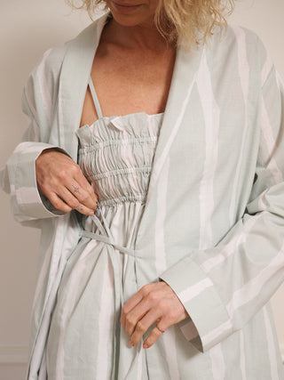 Model wearing women’s aqua brushed stripe cotton robe with tie waist and midi length, photographed barefoot in a neutral studio setting. Back Detail. Tie detail. 