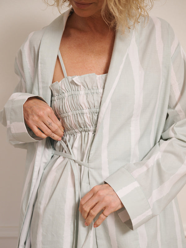 Model wearing women’s aqua brushed stripe cotton robe with tie waist and midi length, photographed barefoot in a neutral studio setting. Back Detail. Tie detail. 