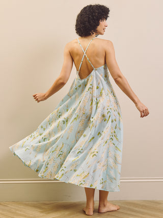 Woman wearing a floral night dress with a beige wall background