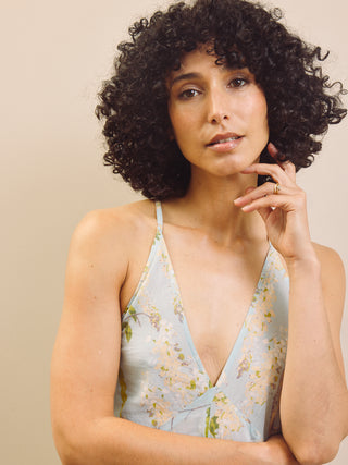 Woman wearing a floral night dress against a beige background