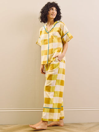model wears yellow large Ingham check pyjama set against a beige wall