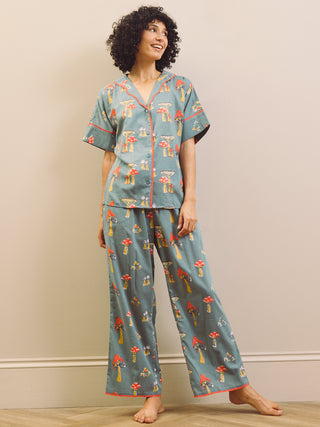 Woman wearing a mushroom patterned oversized pyjama set against a plain background