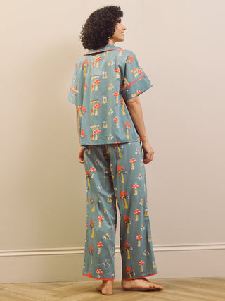 Woman wearing a mushroom patterned oversized pyjama set against a plain background
