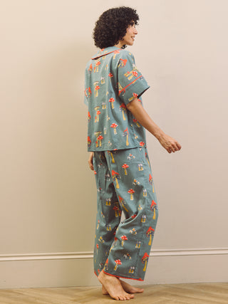Woman wearing a mushroom patterned oversized pyjama set against a plain background